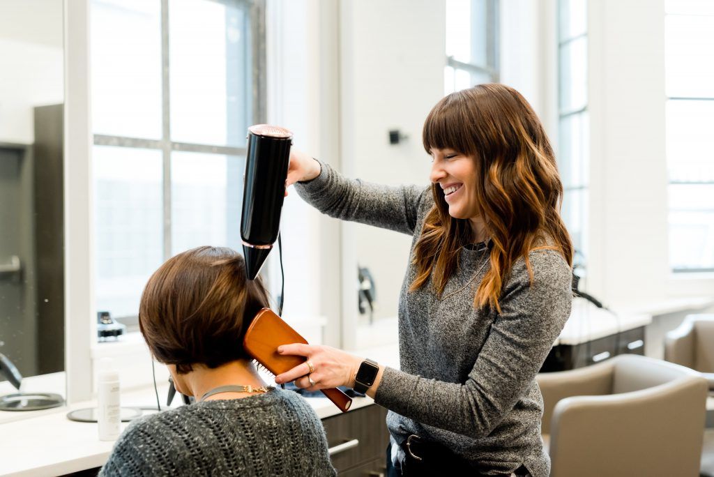 A hairdresser drying a client's hair